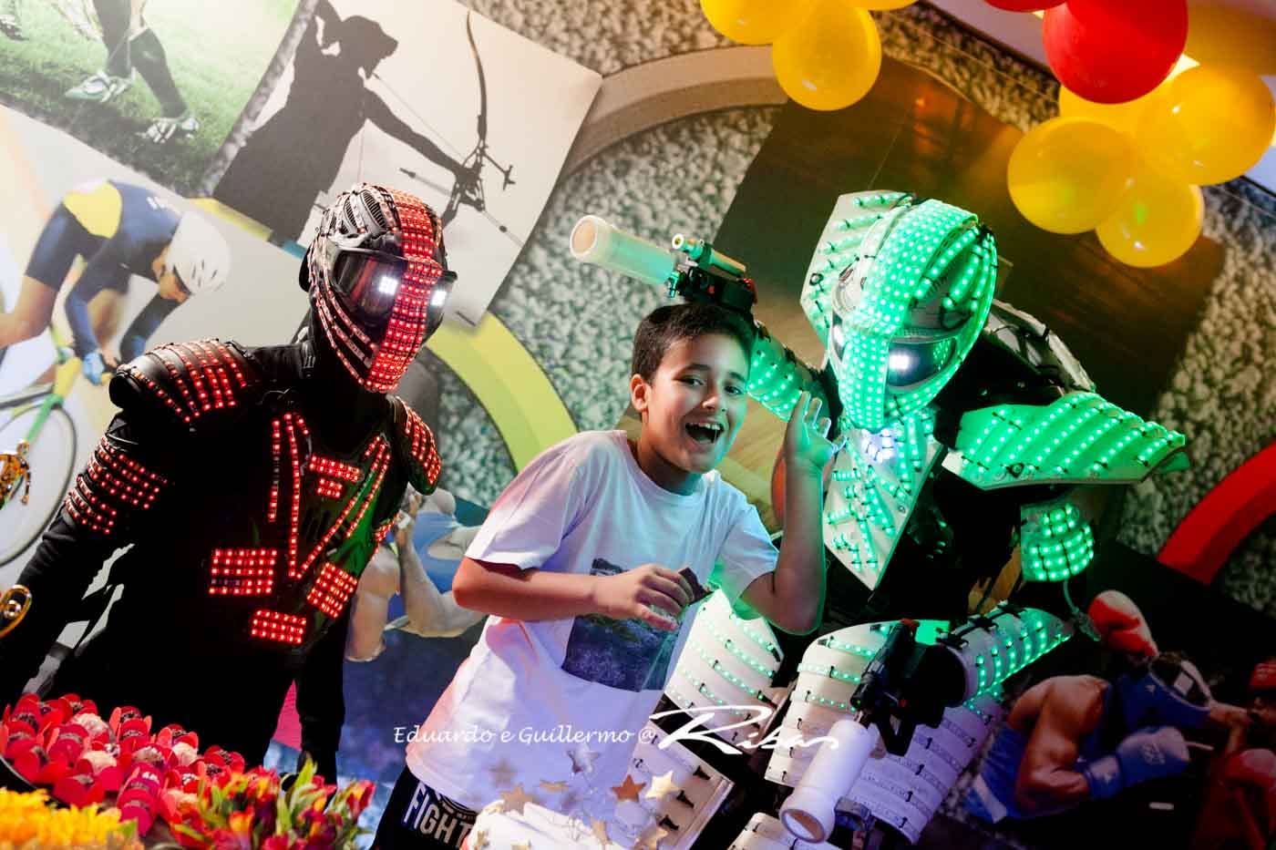 Criança sorrindo entre dois RoboLED iluminados